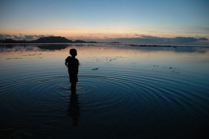 ragazzo nel lago al tramonto